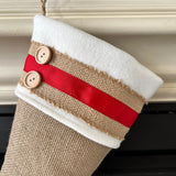 BurlapBabe Christmas stocking in natural burlap with an ivory fleece cuff, red ribbon accents, and two wooden buttons.