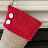 BurlapBabe Christmas stocking in natural jute burlap with a red fleece cuff and two white wooden button accents.