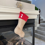 BurlapBabe handmade burlap Christmas stocking with a red fleece cuff and two white wooden buttons hanging on a mantel.
