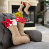 BurlapBabe burlap Christmas stockings with red fleece cuffs and button or bow accents displayed on a grey armchair.