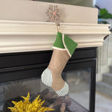 BurlapBabe green ticking and burlap Christmas stocking with a jute hanging loop, displayed on a fireplace mantel.