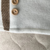 BurlapBabe quilted Christmas stocking featuring white fabric, natural burlap trim, and two round wooden buttons.