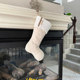 BurlapBabe cream quilted Christmas stocking with wood buttons and jute loop hanging on a fireplace mantel