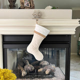 BurlapBabe handmade quilted Christmas stocking in cream with a white cuff hanging on a snowflake mantle hook