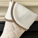 BurlapBabe quilted Christmas stocking in cream fabric with a white fleece cuff and rustic burlap trim