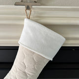 BurlapBabe quilted Christmas stocking with a soft white fleece cuff hanging from a braided jute loop on a mantel.