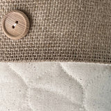 BurlapBabe quilted Christmas stocking featuring a rustic burlap cuff, wooden button detail, and cream quilted fabric.