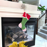 BurlapBabe red and green Christmas stocking with striped toe and cuff hanging from a fireplace mantel