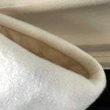 BurlapBabe handmade white quilted Christmas stocking with a soft neutral interior lining hanging on a mantle