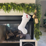 BurlapBabe white quilted Christmas stocking with fleece cuff and red buttons hanging on a fireplace mantel